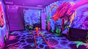 Ein Zimmer mit einem leuchtenden Boden, einem roten Weg und einem Wandgemälde eines Drachen.
