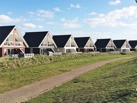 Una hilera de casas de playa con un sendero que las conecta.