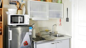 A compact kitchen with a stainless steel refrigerator, a microwave, a sink, and a white cabinet above the counter. - 6 Person Holiday Home in Lysekil (Lysekil)