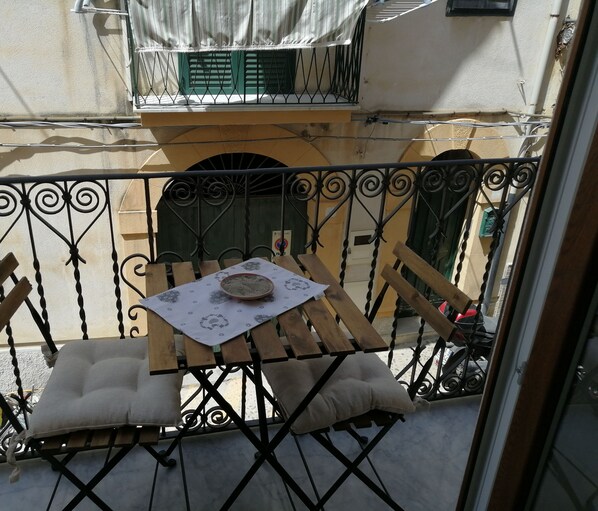 Un balcon avec une table, des chaises et une assiette décorative.