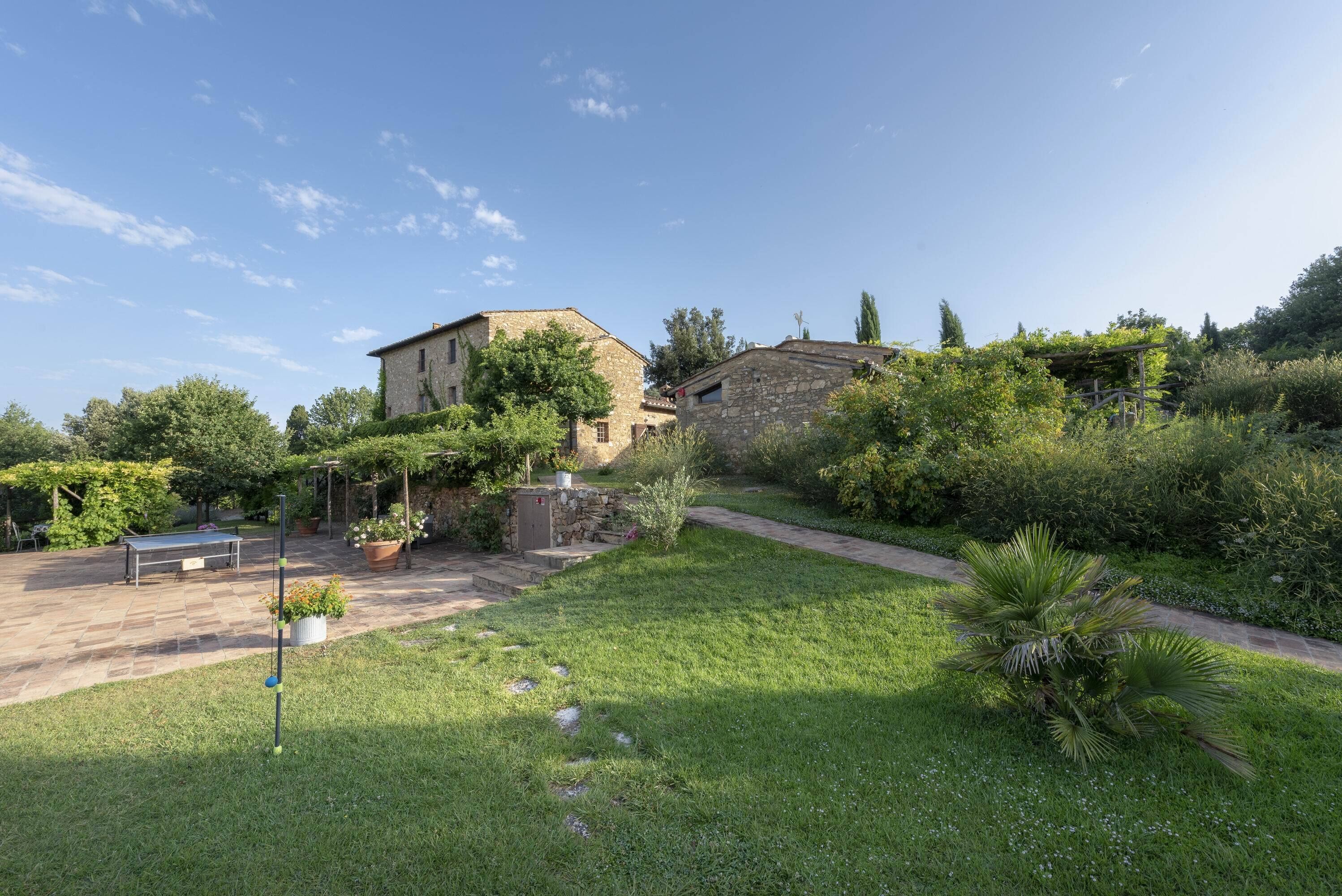 A courtyard with a stone building, a bench, and a pathway.