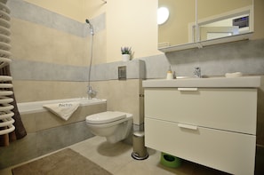 A modern bathroom with a toilet, sink, and shower.