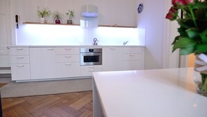 A modern kitchen with white cabinetry, a built-in oven, and a countertop. - Victus Apartamenty - Bolek (Sopot)