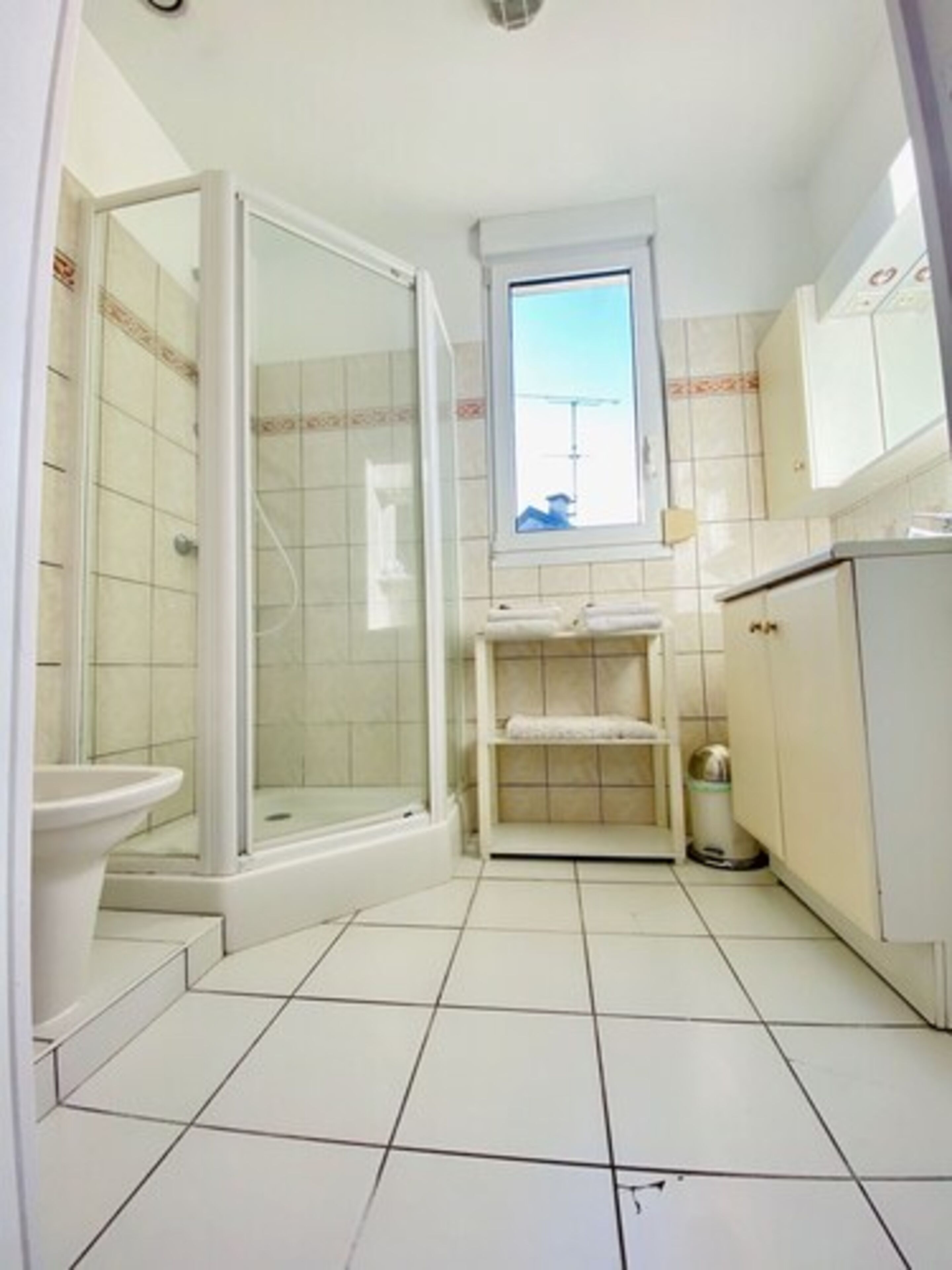 A small, clean bathroom with a shower, toilet, and sink.