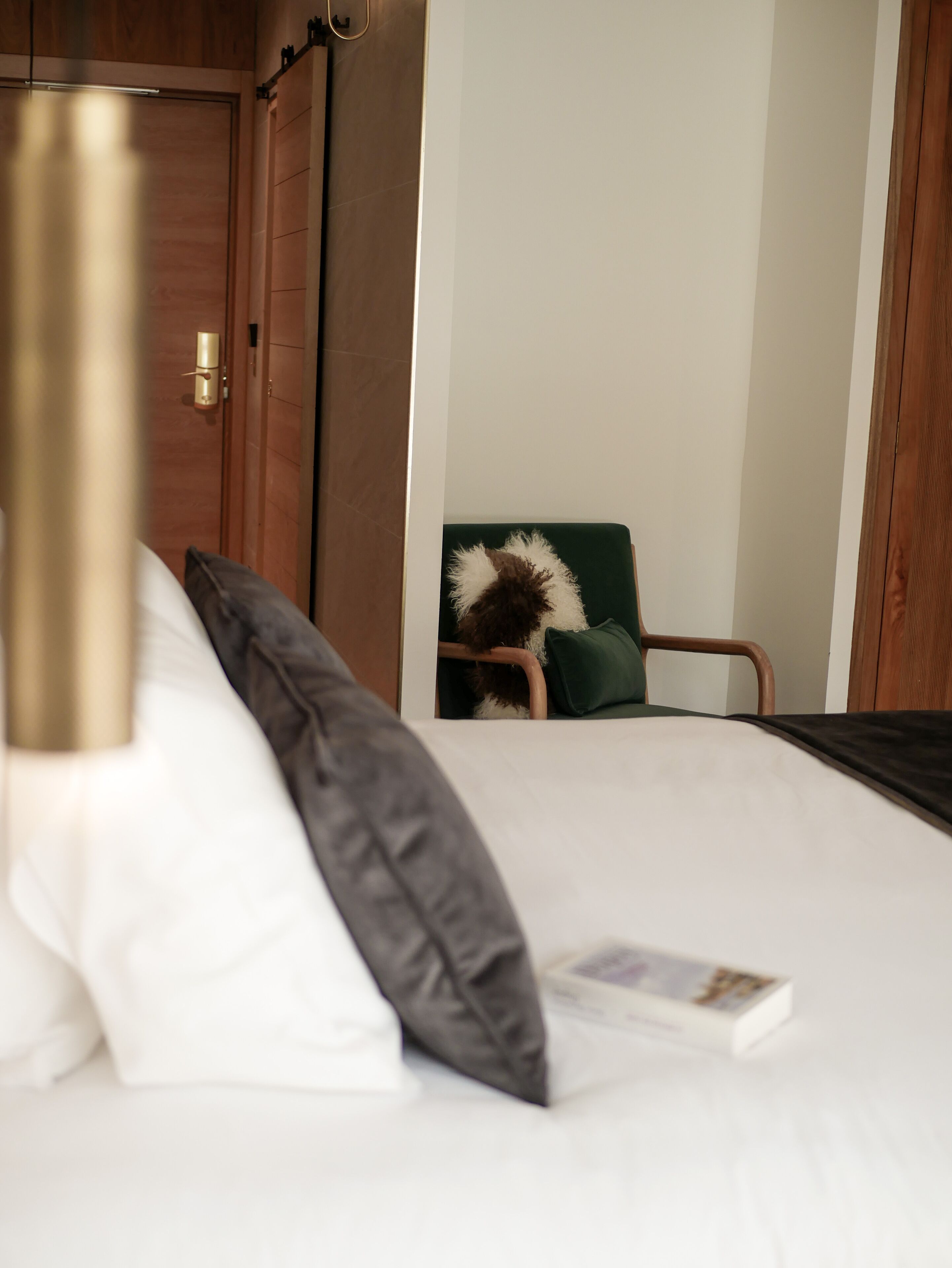 Una habitación de hotel con una cama, una silla y una puerta.