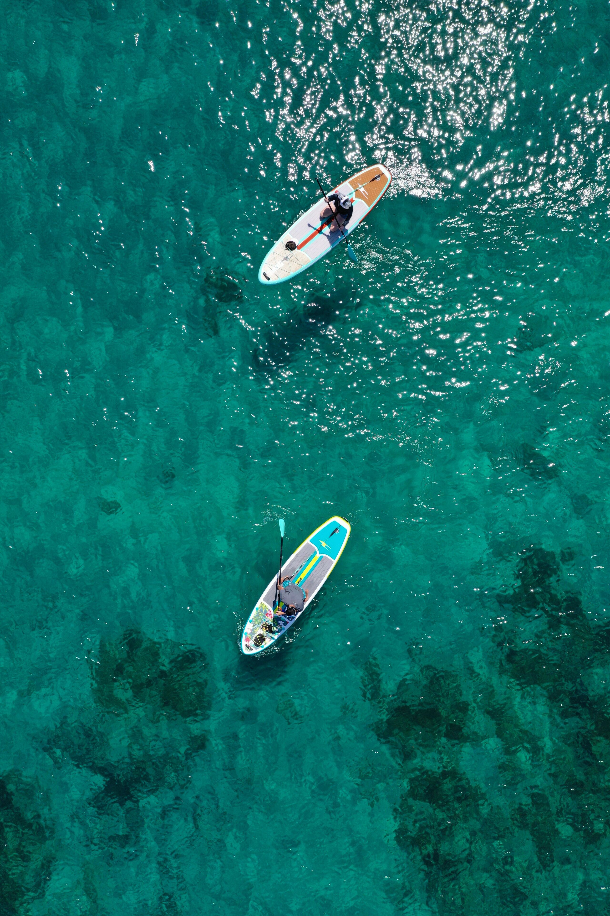 Deux planches de paddle sur une eau turquoise.