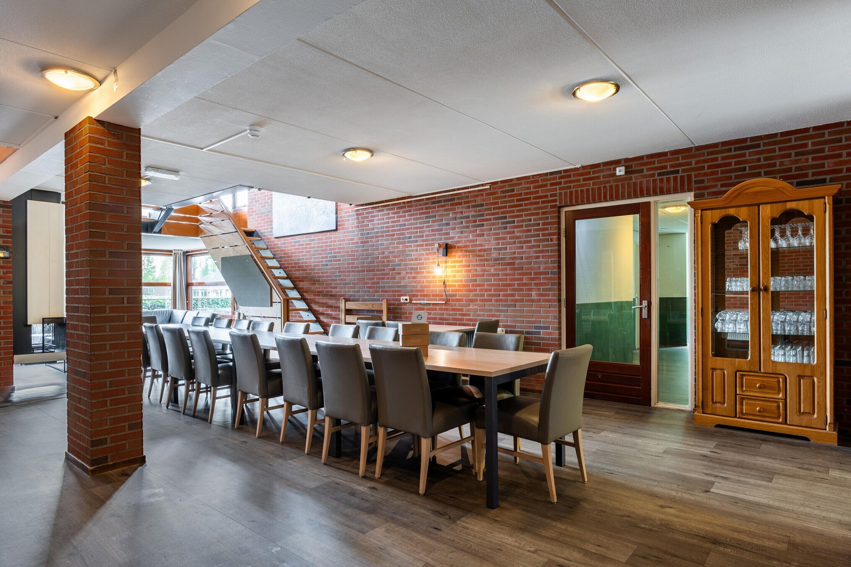 Un coin repas avec un mur en briques, une table en bois et des chaises.