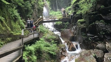 Un puente de madera sobre una cascada con pasarelas de madera a ambos lados.