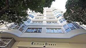 Un edificio de varios pisos con fachada curva y un letrero que dice 'Edificio Tamar'.