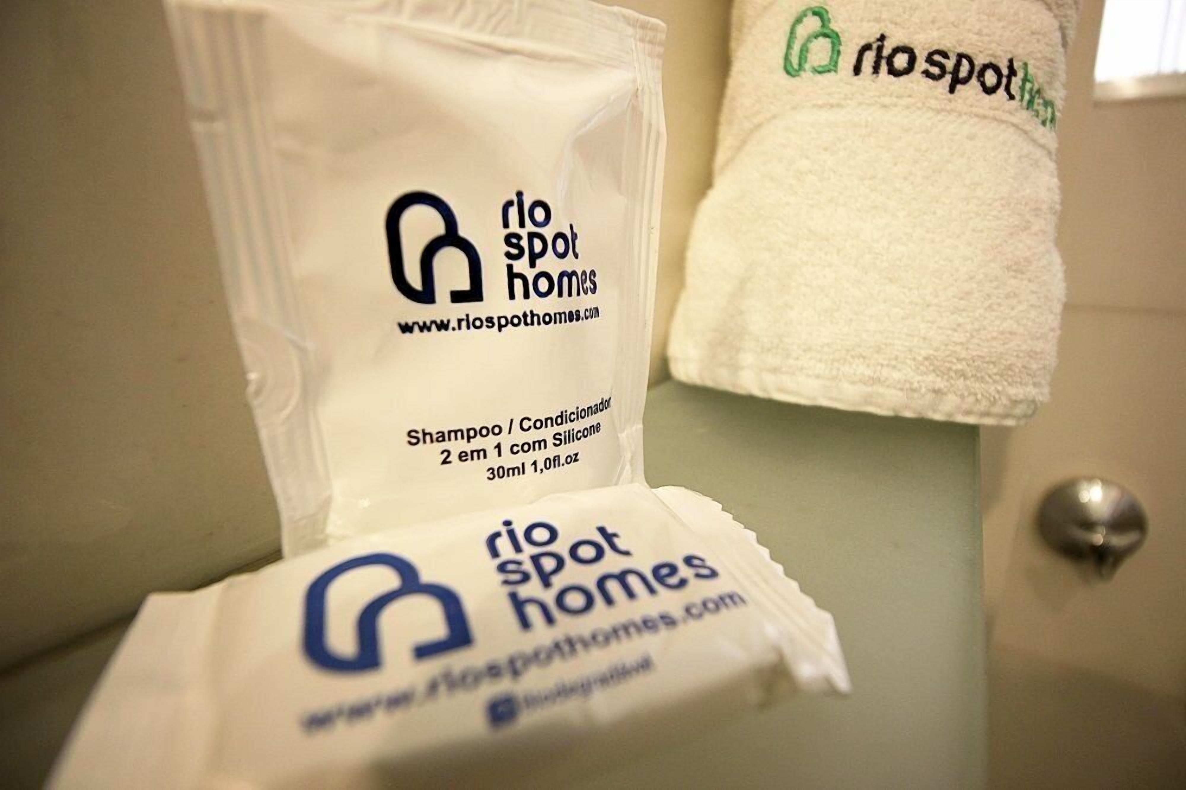 Toilettenartikel, darunter Shampoo und ein Handtuch mit dem Logo von Rio Spot Homes.