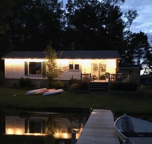 Situated by the water, this cabin offers a tranquil retreat with a dock and outdoor seating area.