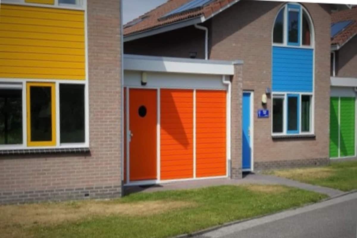 A row of modern houses with distinctively colored doors and windows.