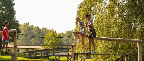A wooden bridge over a body of water with a wooden deck and railings.