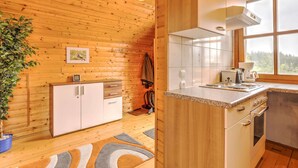 A wooden interior with a kitchen area, including cabinets, a countertop, and a window with a view. - Holiday Home in Liebenfels in Carinthia (Liebenfels)