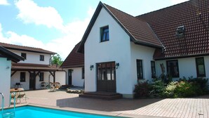 A two-story house with a swimming pool, a patio with outdoor furniture, and a garden area. - Schones Ferienhaus in Dargun mit Pool (Dargun)