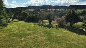 A grassy field with trees and a distant hill. - Spacious Apartment in Schonsee With Sauna (Schoensee)