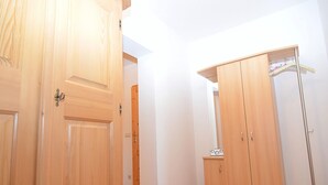A hallway with wooden doors and a wardrobe with a mirror. - Spacious Apartment in Schonsee With Sauna (Schoensee)