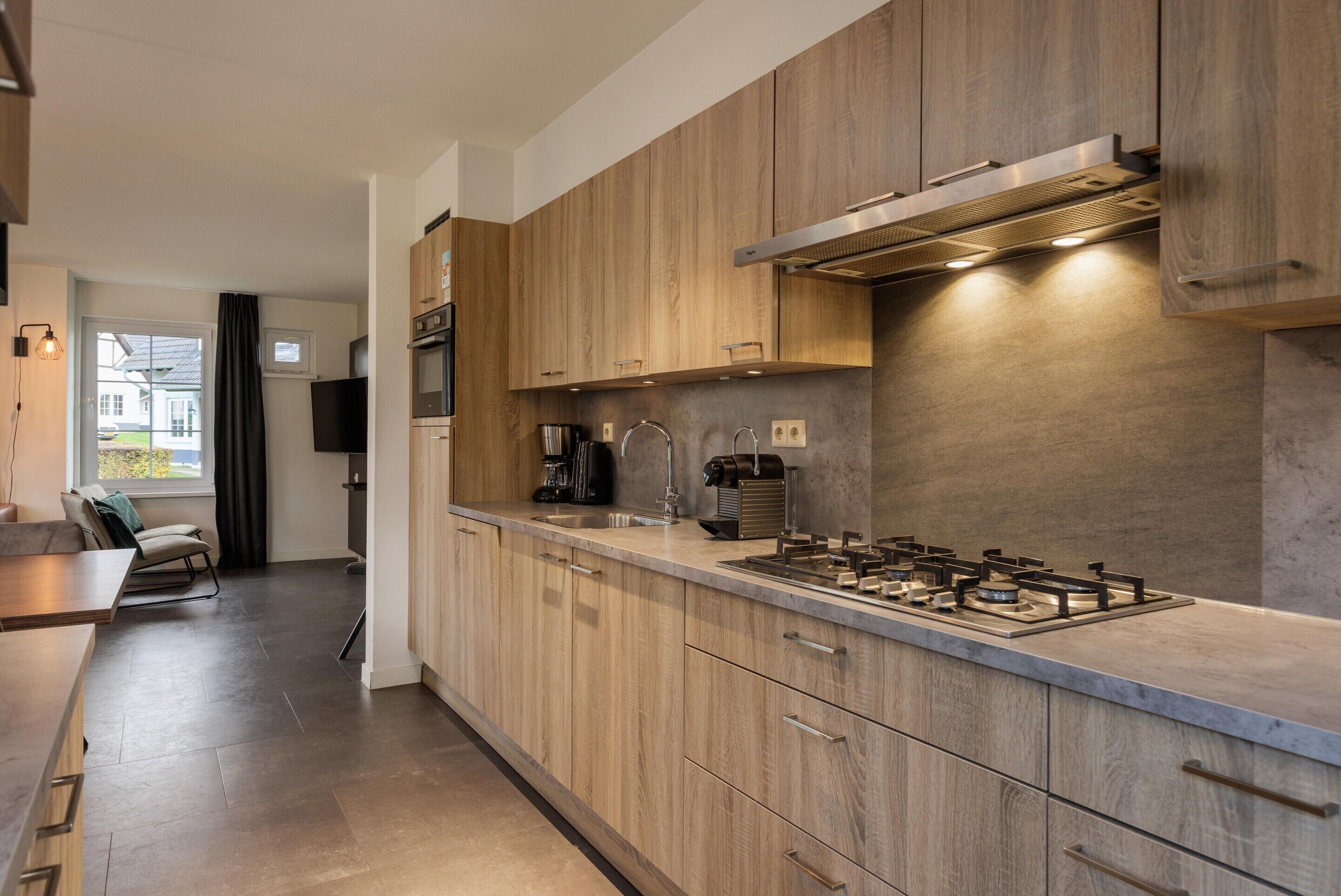 A modern kitchen with wooden cabinets, a gas stove, and a built-in oven.
