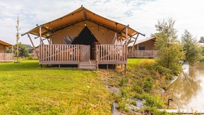 A tented accommodation with a wooden deck and a view of a water body. - Detached Holiday Home With Garden Near Hoorn (Andijk)