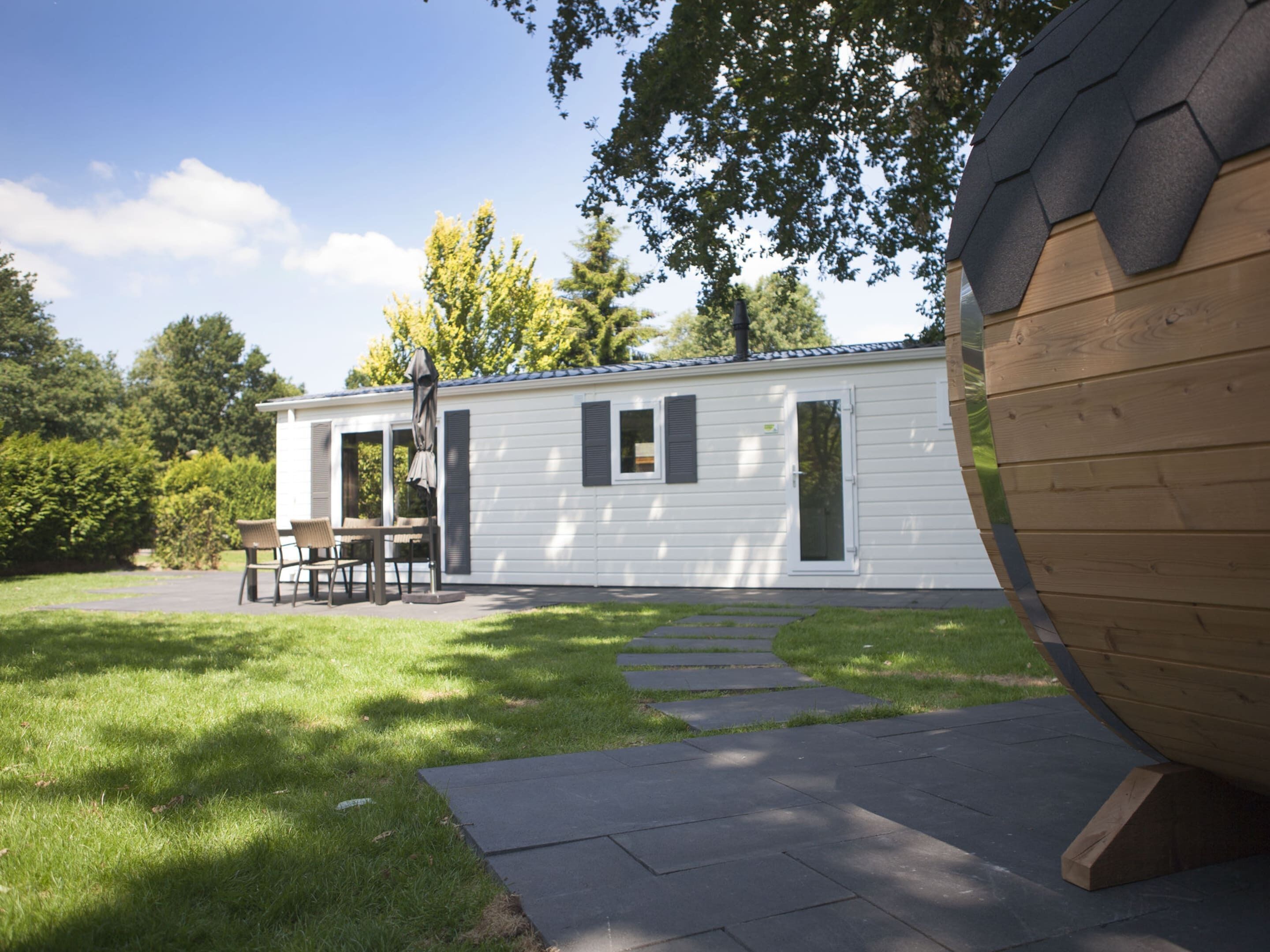 A mobile home with a patio area, a dining table, and chairs.