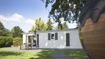 A mobile home with a patio area, a dining table, and chairs.