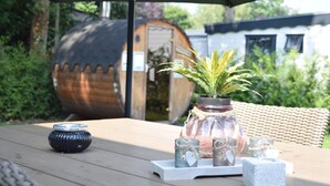 A wooden table with a potted plant, candle holders, and a tray. - Wellness Chalet in Nature (Voorthuizen)