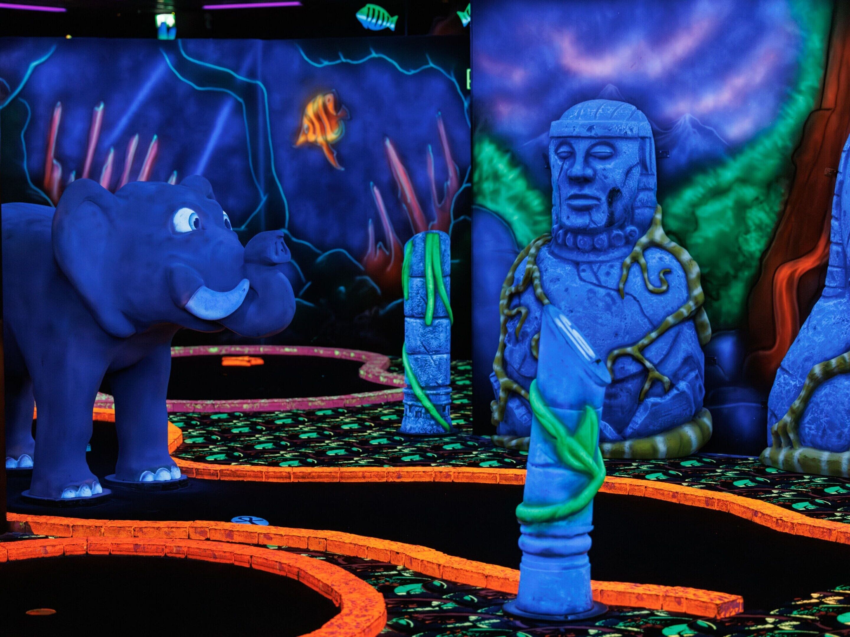 A statue of a figure in armor standing on a platform with a large elephant nearby.