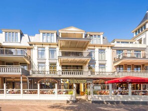 Experience the classic charm of this hotel, featuring a central entrance and multiple balconies with outdoor space.