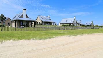 A rural property with multiple houses, a dirt road, and a wooden fence.