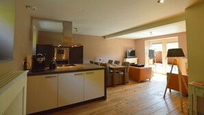 Een moderne keuken met een eethoek, een televisie en uitzicht op de omgeving.