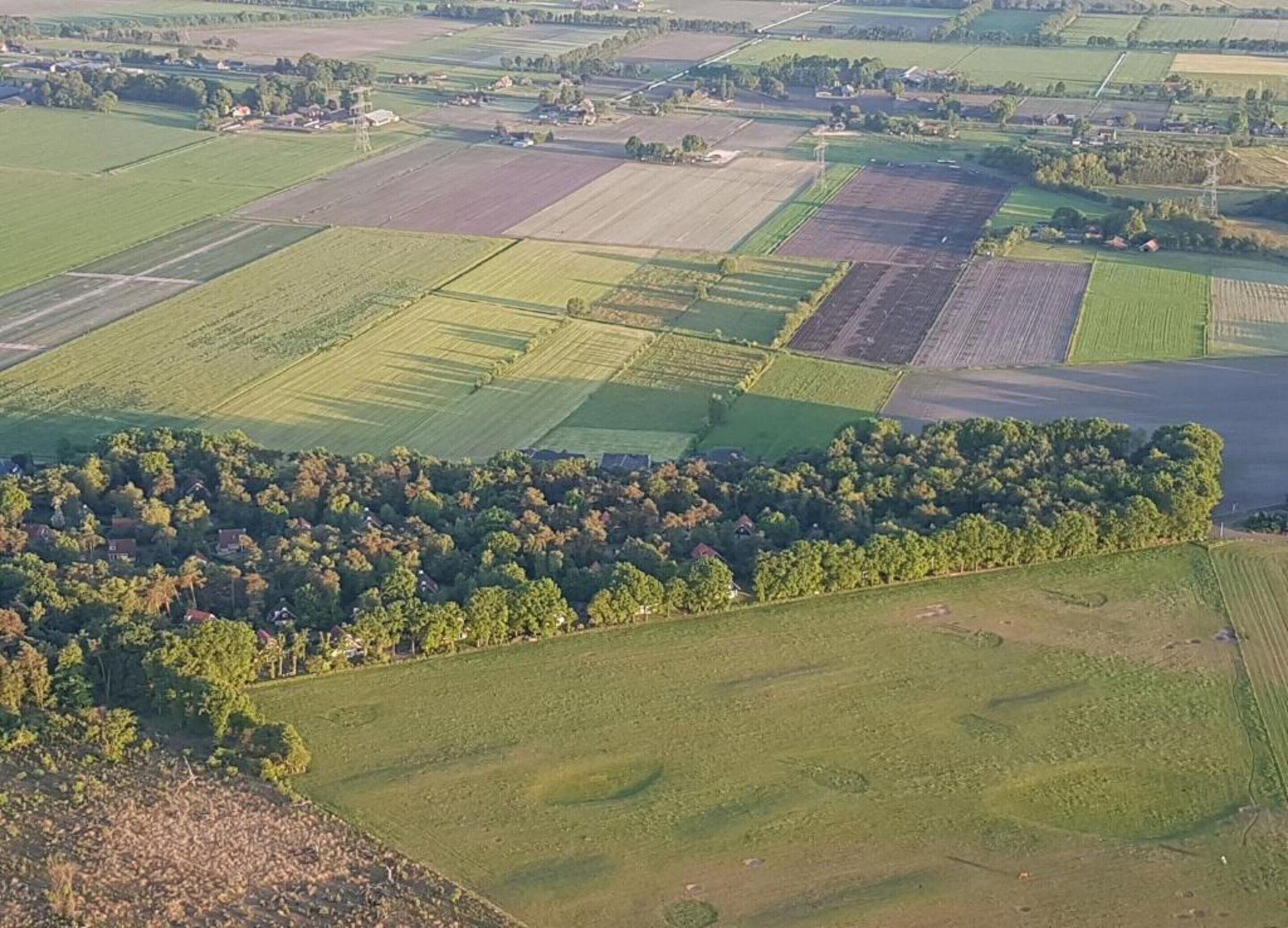 An aerial view of a rural landscape with fields and scattered houses.