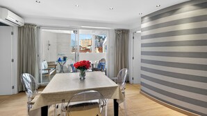 Un comedor moderno con una mesa, sillas y vistas a través de puertas de cristal.
