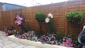 Een houten hek met diverse planten en bloemen.