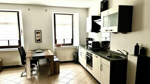 A compact kitchen with a dining table, a built-in oven, and a microwave.