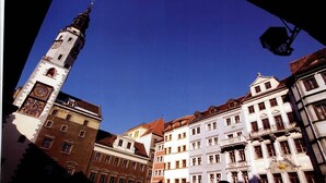 A historic building with a prominent clock tower and a clear blue sky.
