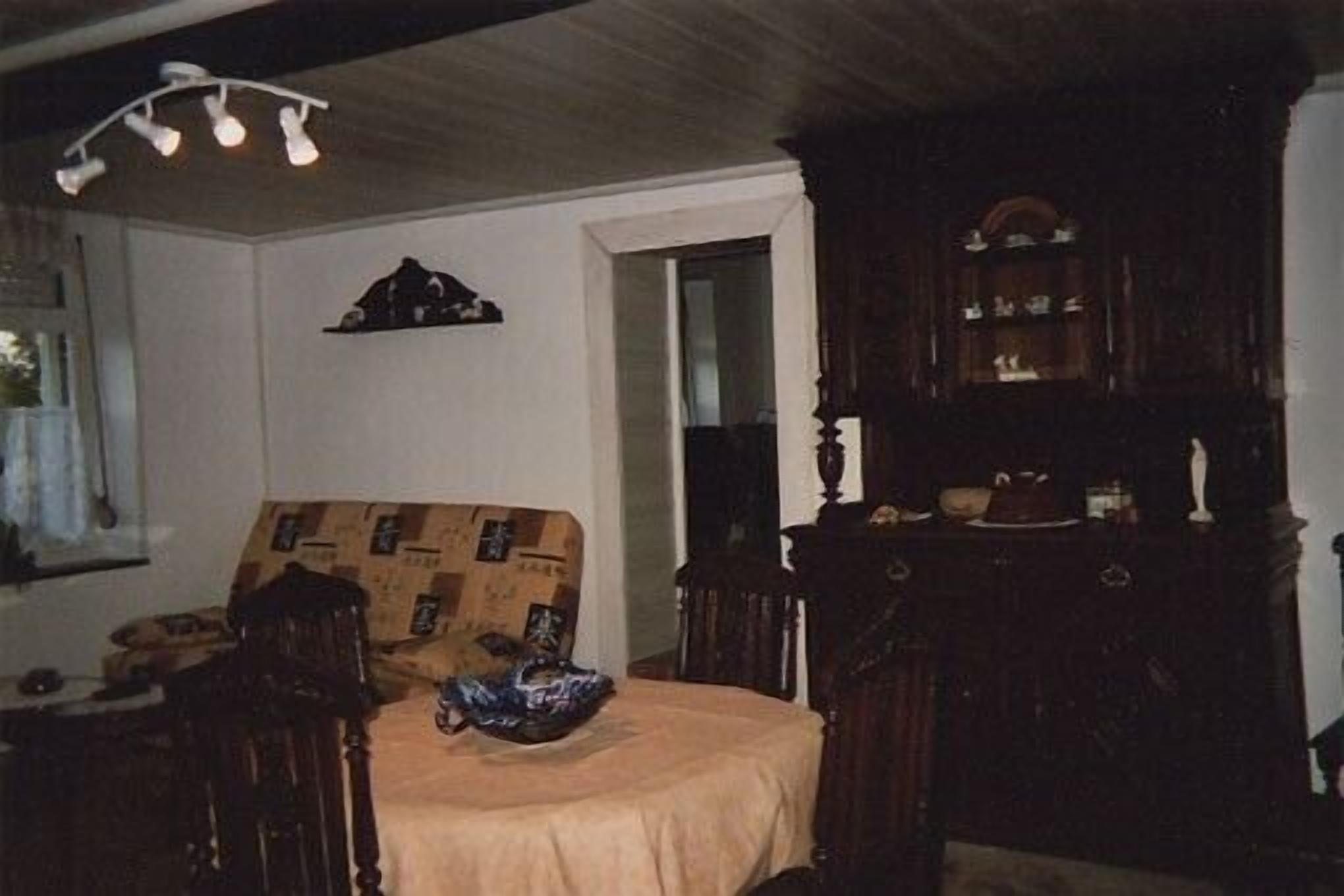 A room with a bed, a wooden dresser, and a mirror.