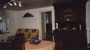 A room with a bed, a wooden dresser, and a mirror.