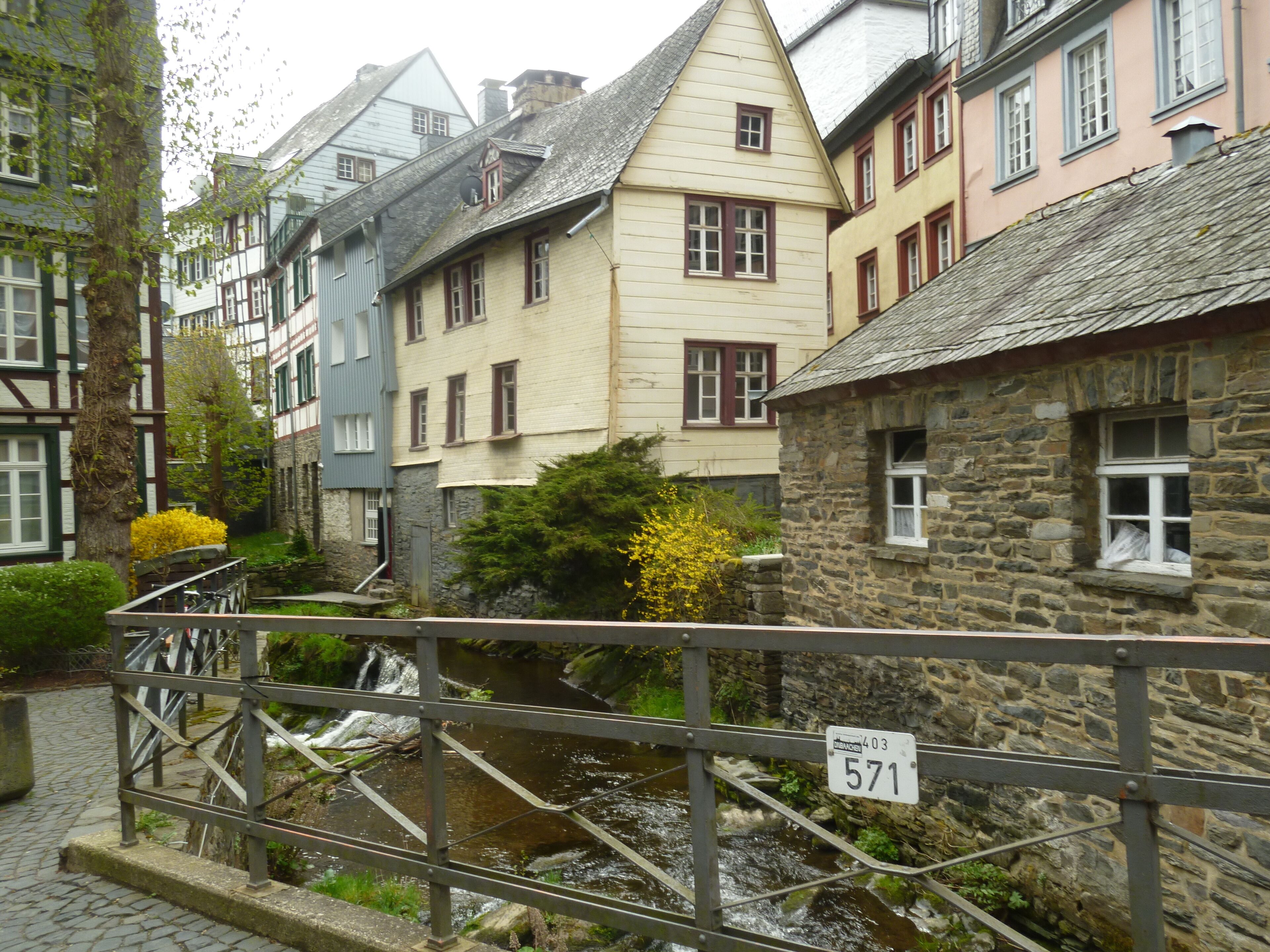 A stone building with a traditional European architectural style, featuring a steeply pitched roof and a small window with a shutter.