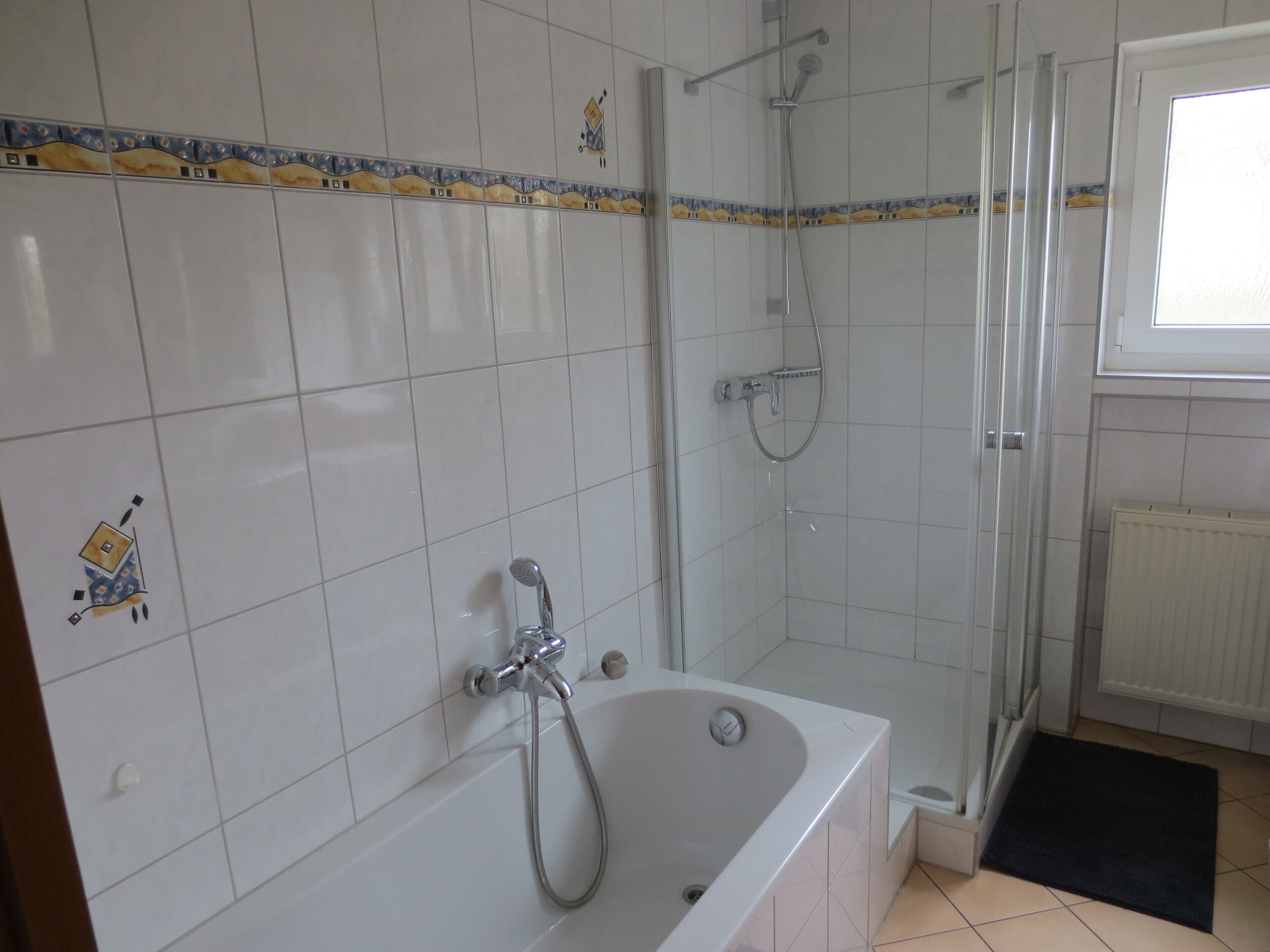 Een badkamer met een bad, douche en toilet.