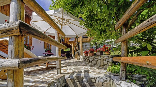 A stone-paved pathway leading to a wooden structure with a white umbrella. - Sobol in Kočičin (Haus für 6-9 Personen) (Kuzelj)