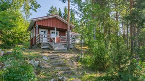 A rustic cabin with a wooden staircase leading to a porch, surrounded by dense forest. - Kiviaho by Interhome (Parikkala)