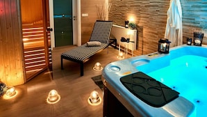 Une salle de bain moderne avec un plancher en bois, une baignoire, une chaise longue et un radiateur fixé au mur.