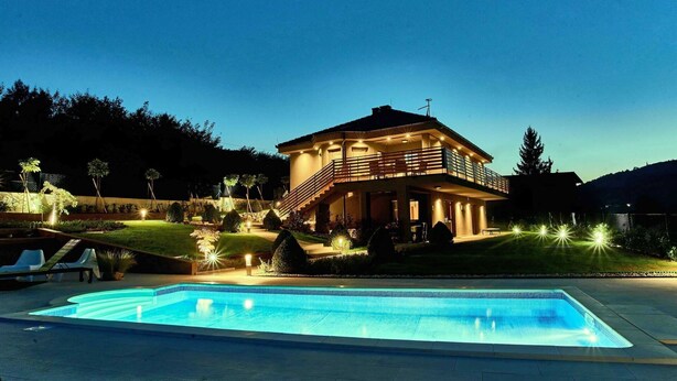 Une maison à deux étages avec une piscine à l’avant.