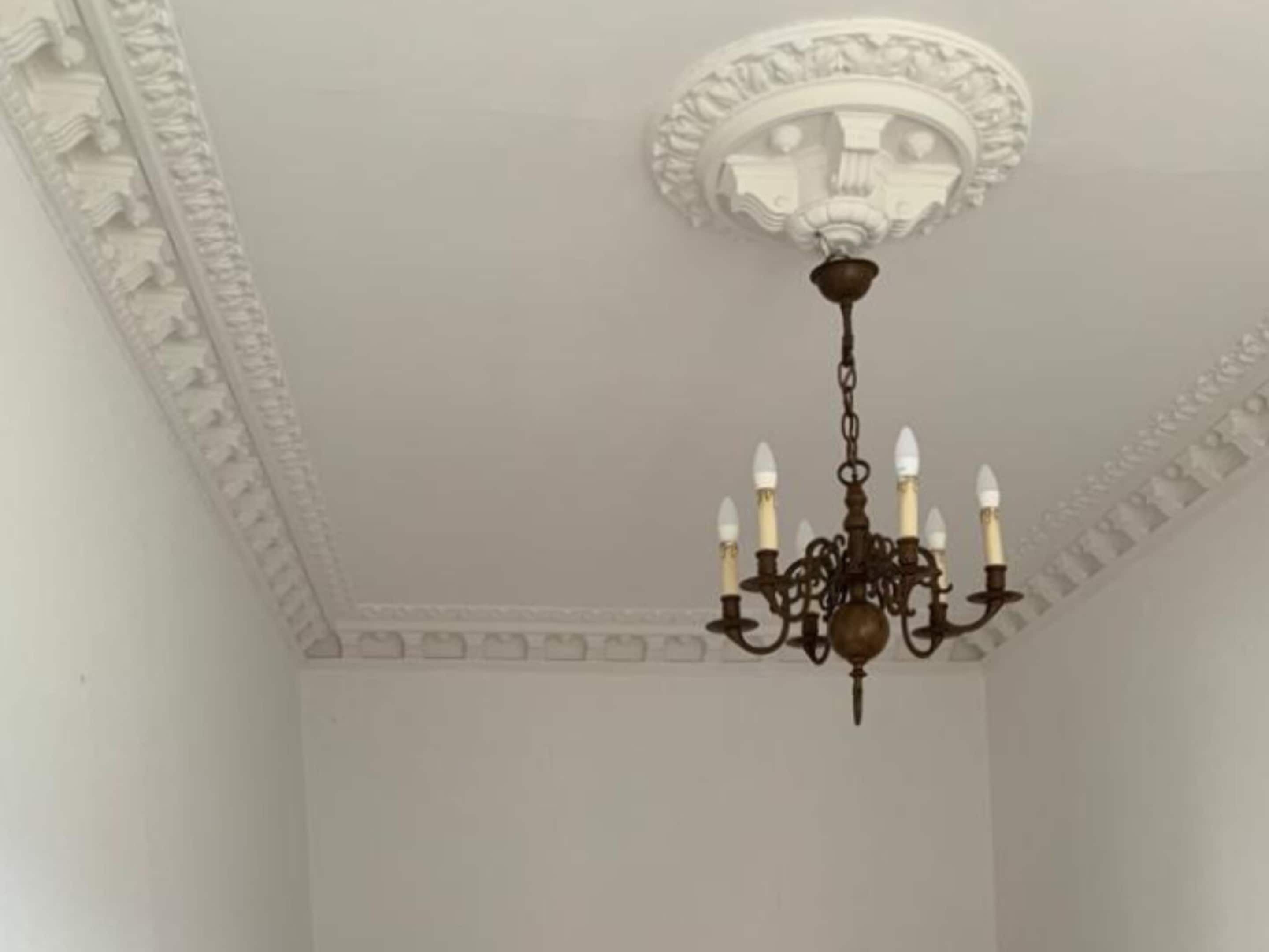 A room with a white ceiling and a decorative white molding.