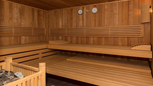A sauna with wooden benches, a slatted bench, and a wall-mounted heater. - Apartment in Bergheim Near Picturesque Town (Bergheim)