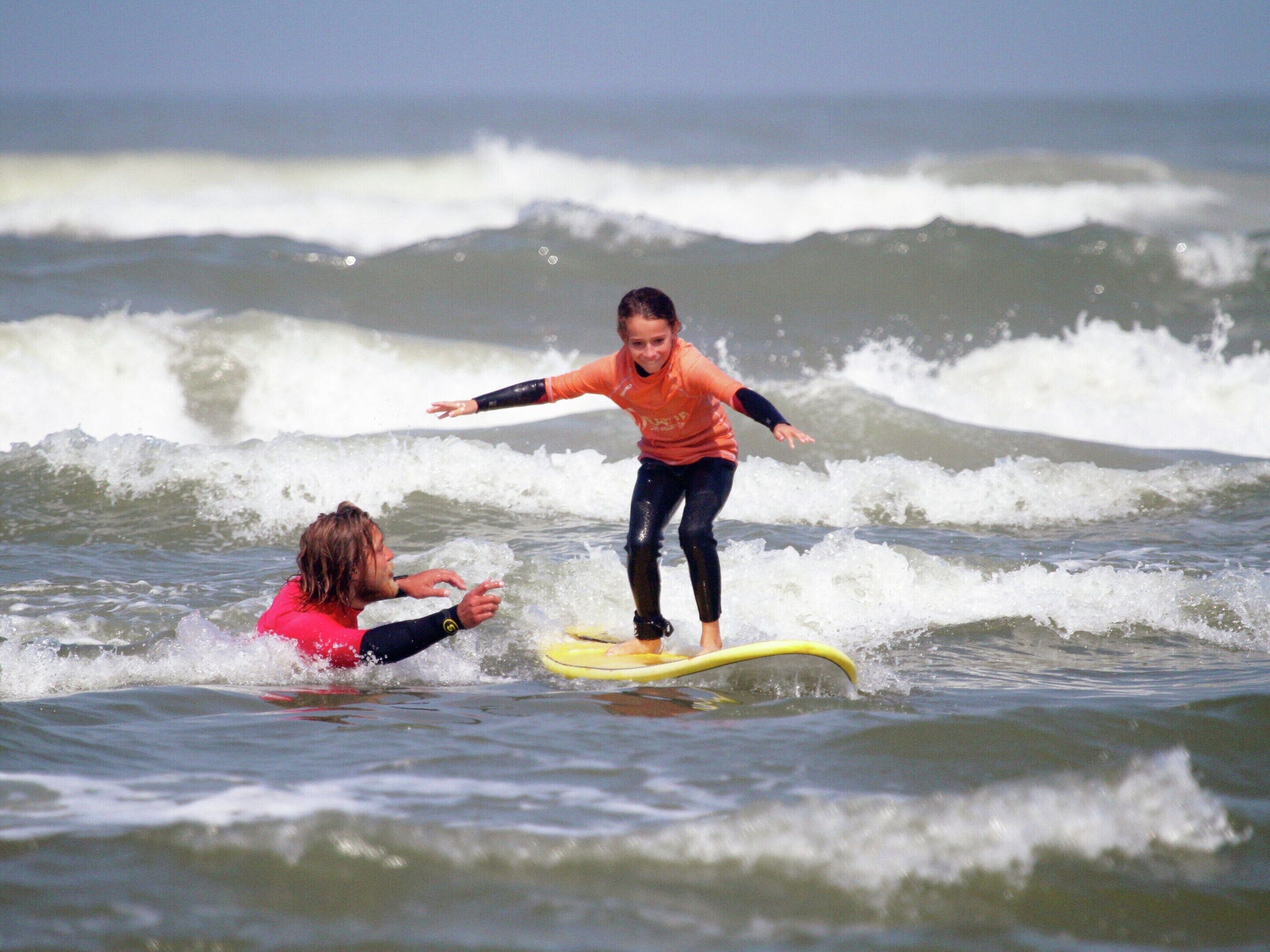 Eine Person surft im Meer bei Wellen.