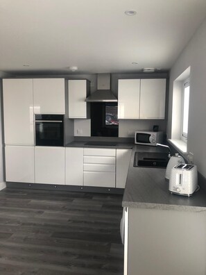 Appartamento Deluxe, bagno privato, vista mare parziale | Cucina condivisa