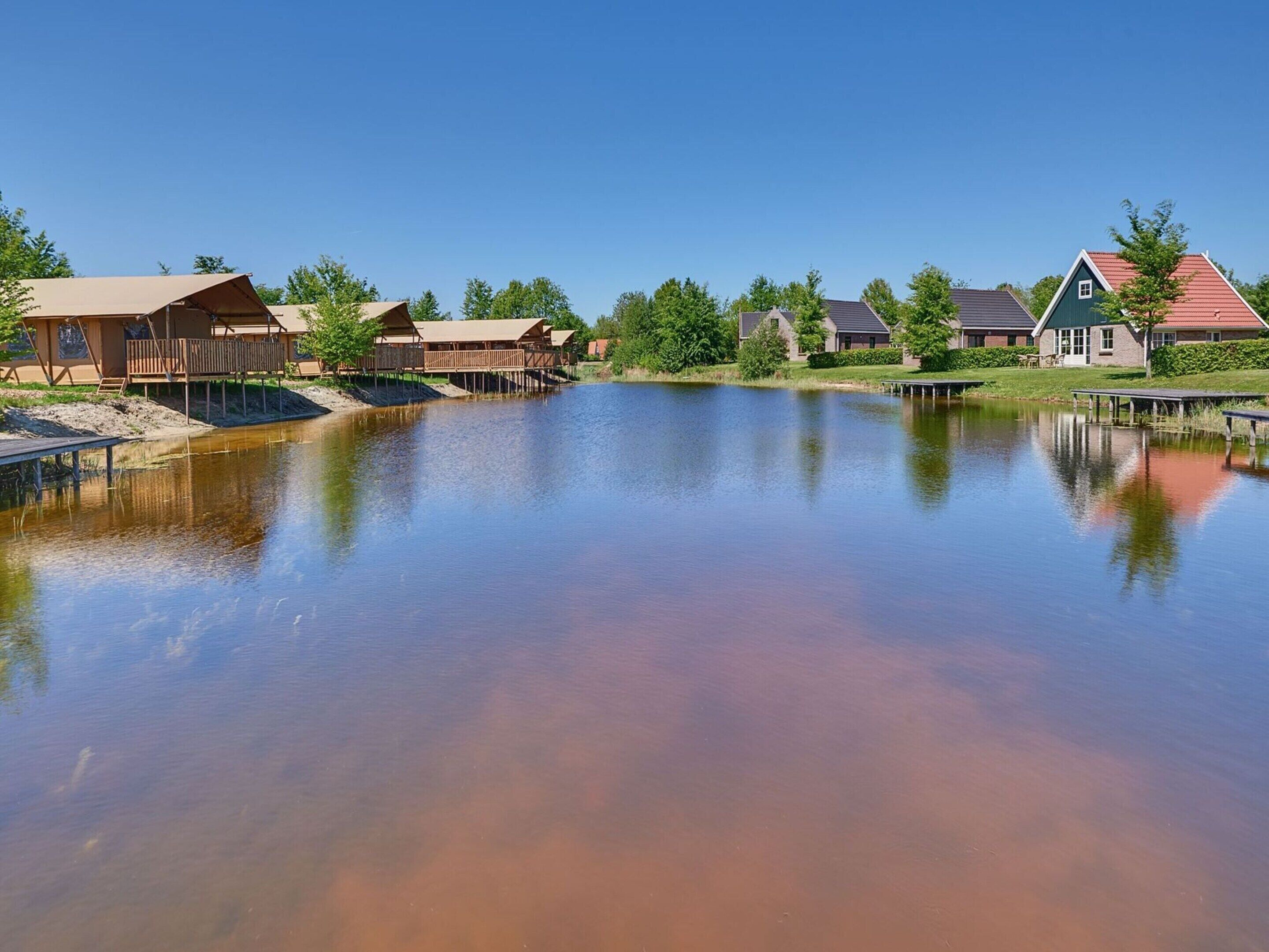 A lakeside property with wooden cabins and a dock.