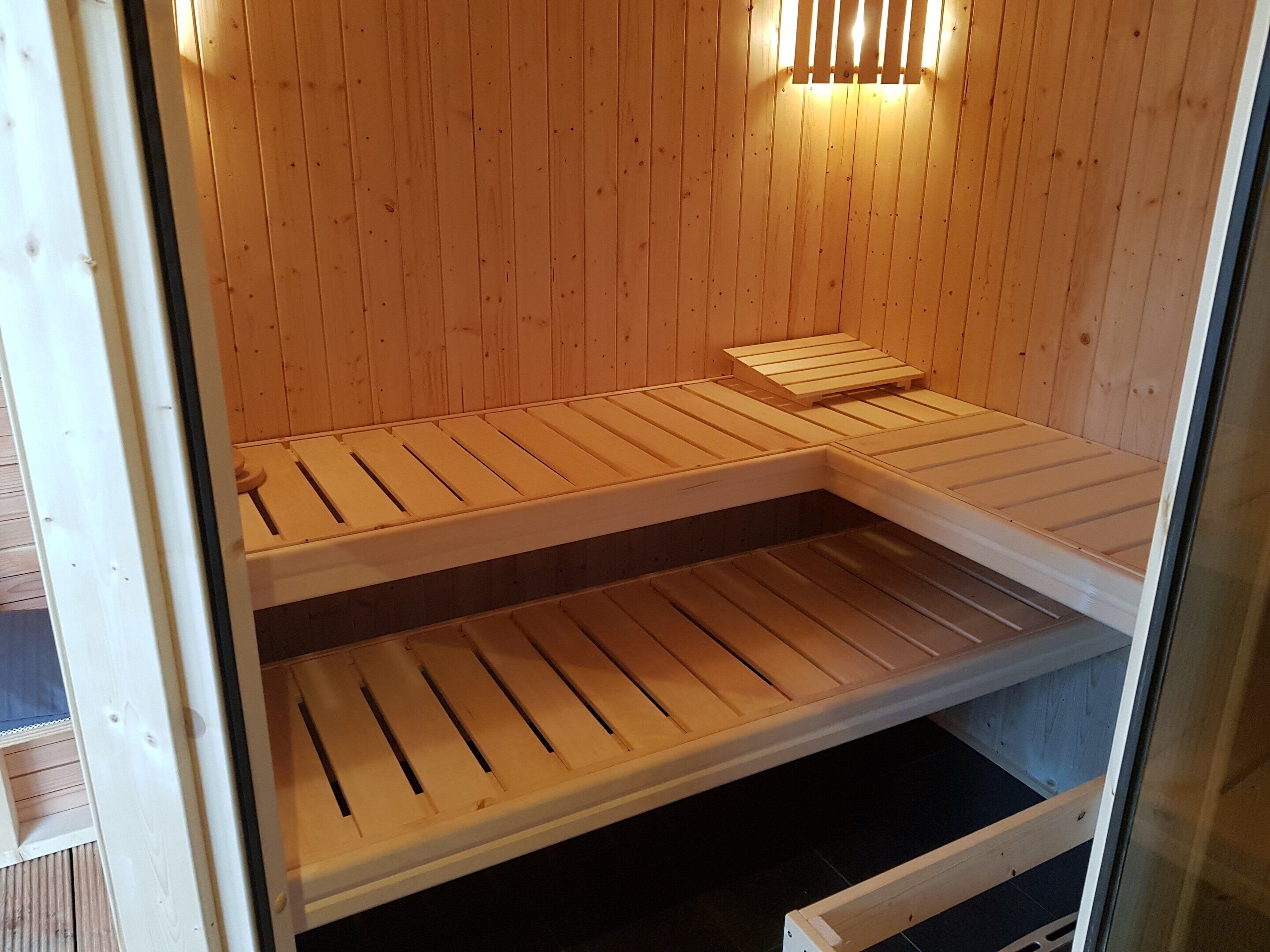 A sauna with wooden benches and a bench on the floor.