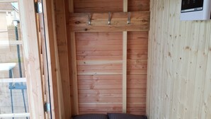 A small, wooden room with a bed, a sauna control panel, and a window. - Nice Holiday Home with Sauna & Hot Tub near Wadden Sea (Tzummarum)